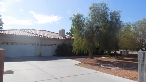 Front exterior of a single-story facility with a two-car garage and trees