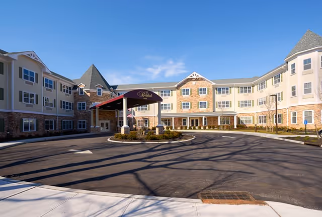 Exterior view of The Bristal Assisted Living at Lake Grove entrance and circular driveway.