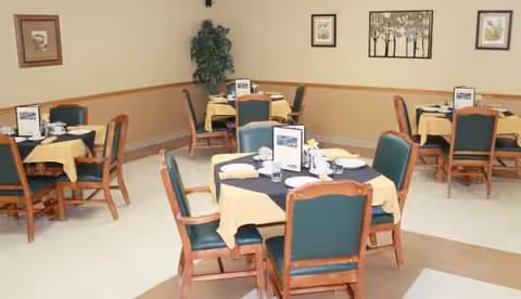 Dining room in a senior living facility with round tables set for meals.