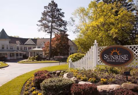 Exterior view of Sunrise Senior Living Morris Plains with sign and landscaped entrance.