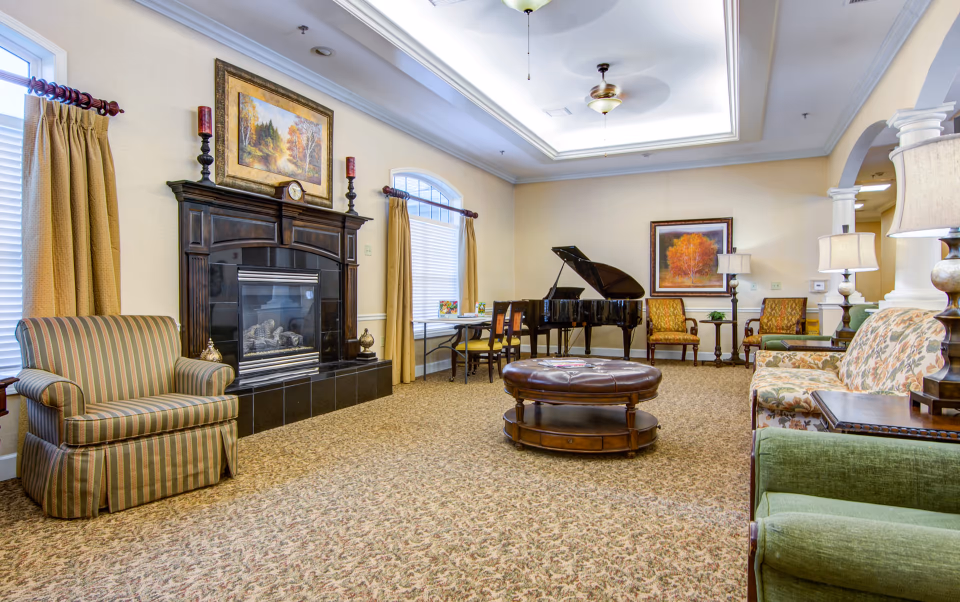 Spacious furnished common living room with seating, a fireplace, and a grand piano.