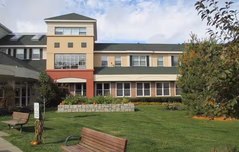 Exterior view of Hearthstone Alzheimer's Care at Marlborough building with benches and lawn