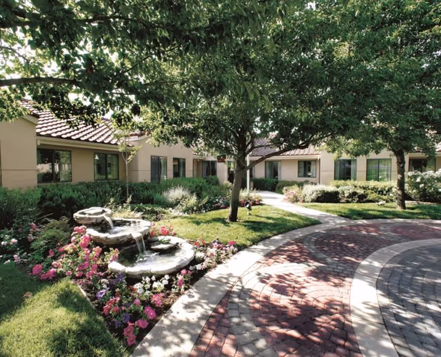 The Forum at Rancho San Antonio exterior courtyard with fountain and trees.