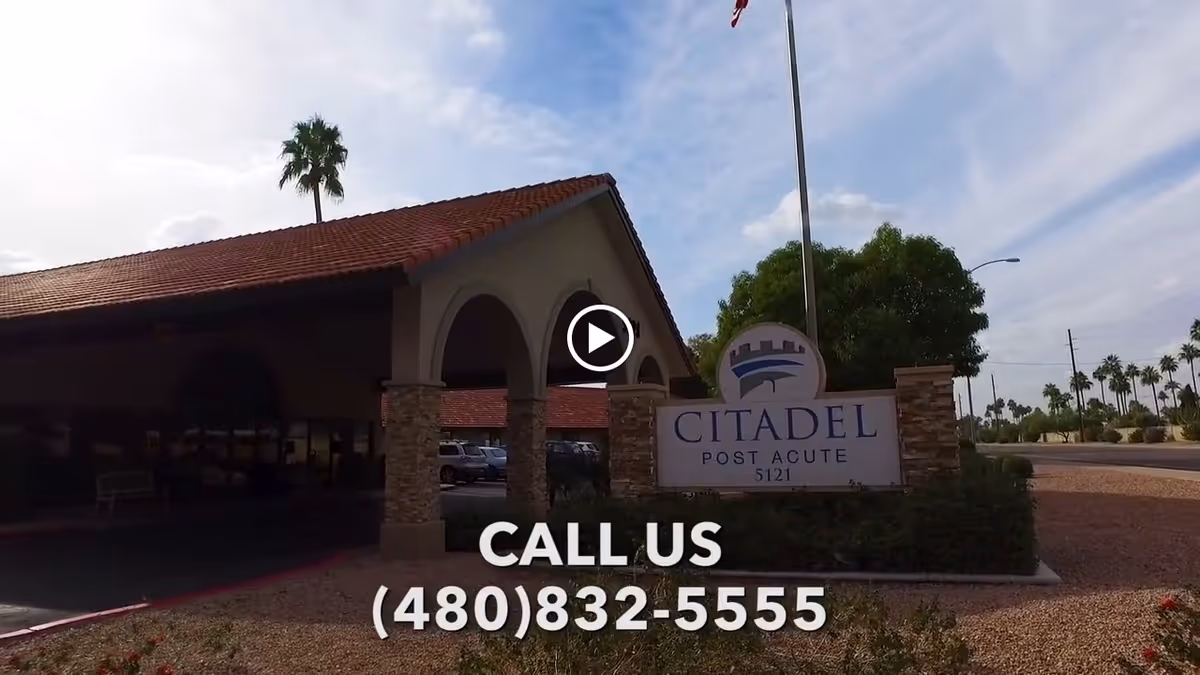 Exterior view of Citadel Post Acute facility with a covered entrance supported by stone pillars and a sign displaying the facility name and phone number. Palm trees and a partly cloudy sky are visible in the background.