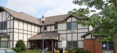 Exterior view of Deane Hill Place Senior Living building with Tudor-style facade and entryway.