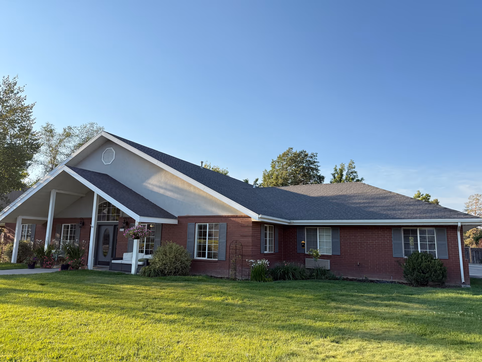 Single story brick senior living facility with a front porch and green lawn.