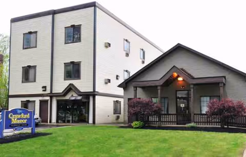 Exterior view of Crawford Manor Health Care Center with lawn and front entrance