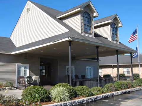 Front view of Ormond Nursing & Care Center entrance with a covered porch and seating.
