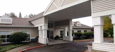 Covered entryway of Brookdale Mt. Hood senior living facility with driveway and landscaping.
