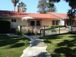 Exterior of Belrose Care Home: a single-story building with a red-tiled roof and walkway.