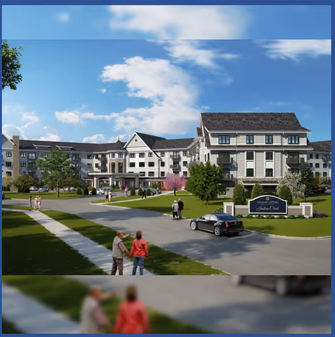 Front view of the Grand Living At Indian Creek multi-story senior living building with landscaped lawns, a driveway, a parked car, and people near the entrance sign.