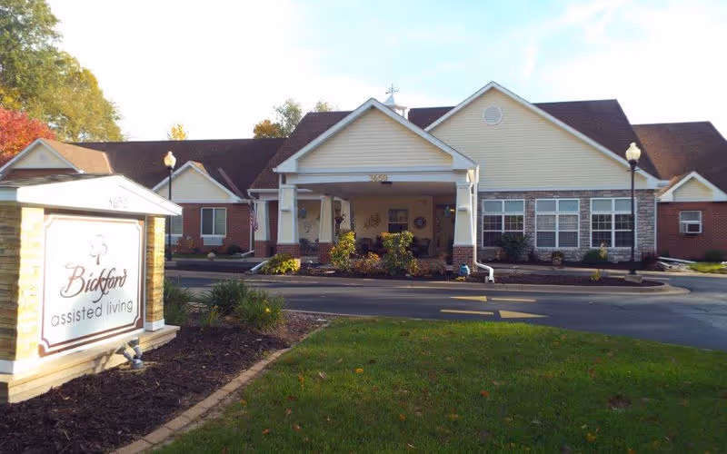 Front exterior of the Bickford assisted living building with a covered porte-cochère entrance and a sign on the lawn.