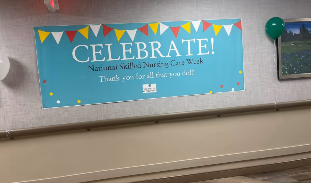 Hallway wall with a large "CELEBRATE!" banner for National Skilled Nursing Care Week and balloons.
