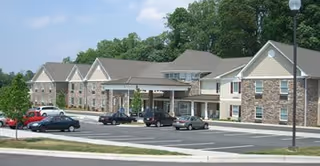Exterior view of Arbor Ridge at Kernersville with a parking lot and covered entrance.