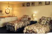 Two floral twin beds with lamps and a dresser in a cozy Desert Cove bedroom.