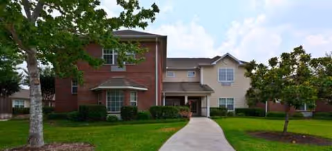 Exterior view of Brookdale Willowbrook Place, a senior living facility with a central entrance and lawn.
