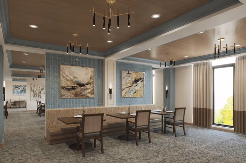 A modern dining room with wooden tables and chairs arranged neatly. The walls feature abstract paintings and blue tile accents. The ceiling has recessed lighting and contemporary chandeliers. Large windows with beige and brown curtains allow natural light to brighten the space.