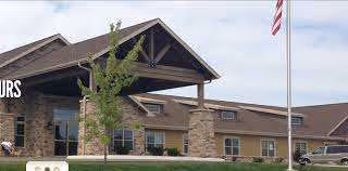 Exterior view of Anna's House senior living facility, featuring stone facade and an American flag.