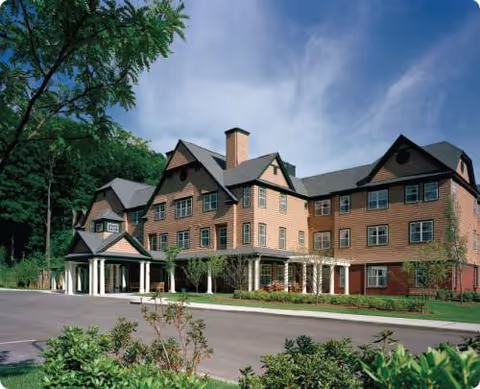 Exterior front view of Cedar Mountain Commons, a brick senior living facility with gabled roofs.