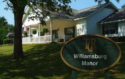 Exterior view of Williamsburg Manor with front porch and lawn sign.