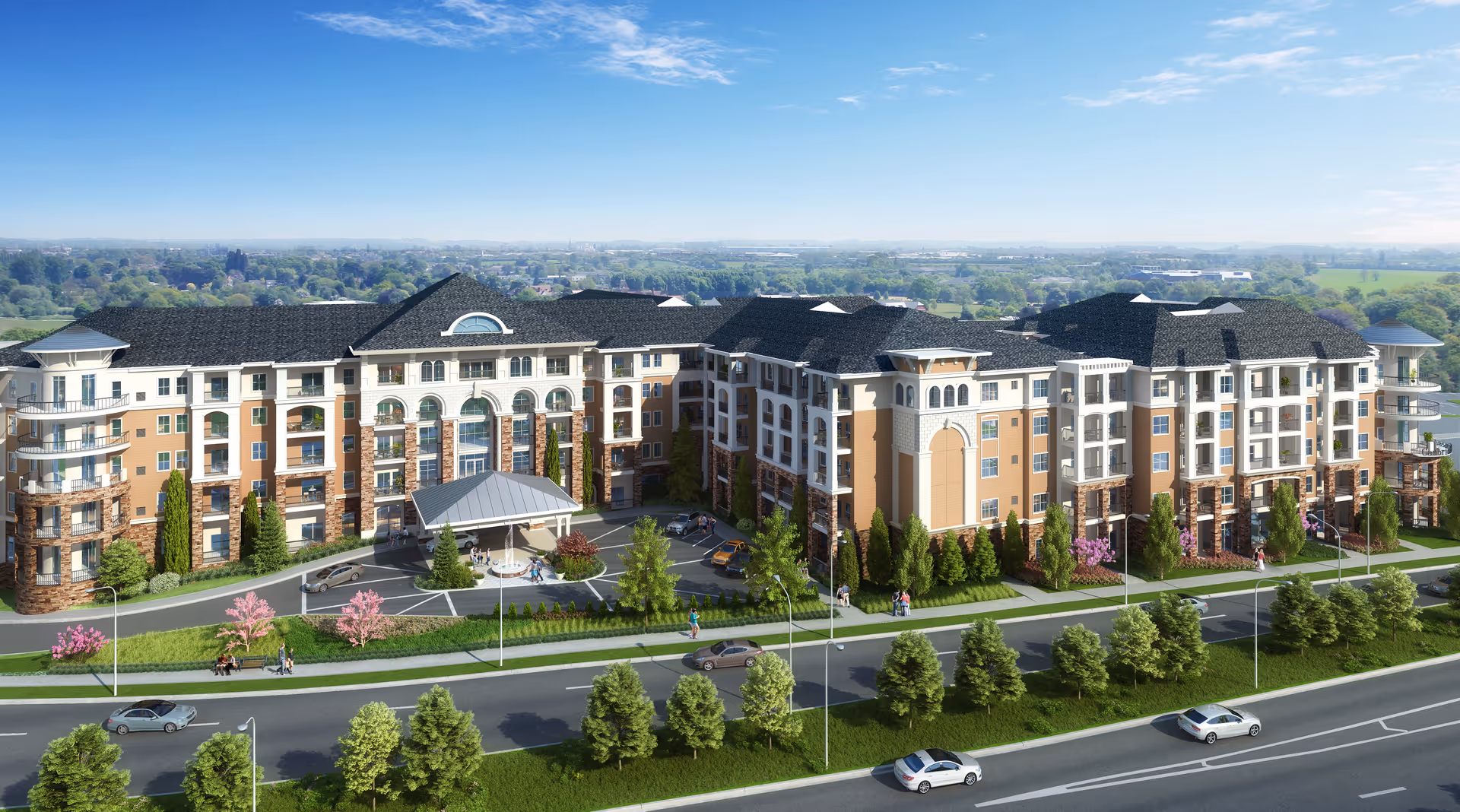 Aerial view of a large multi-story senior living building with a porte-cochère, landscaped grounds, and cars on the road in front.