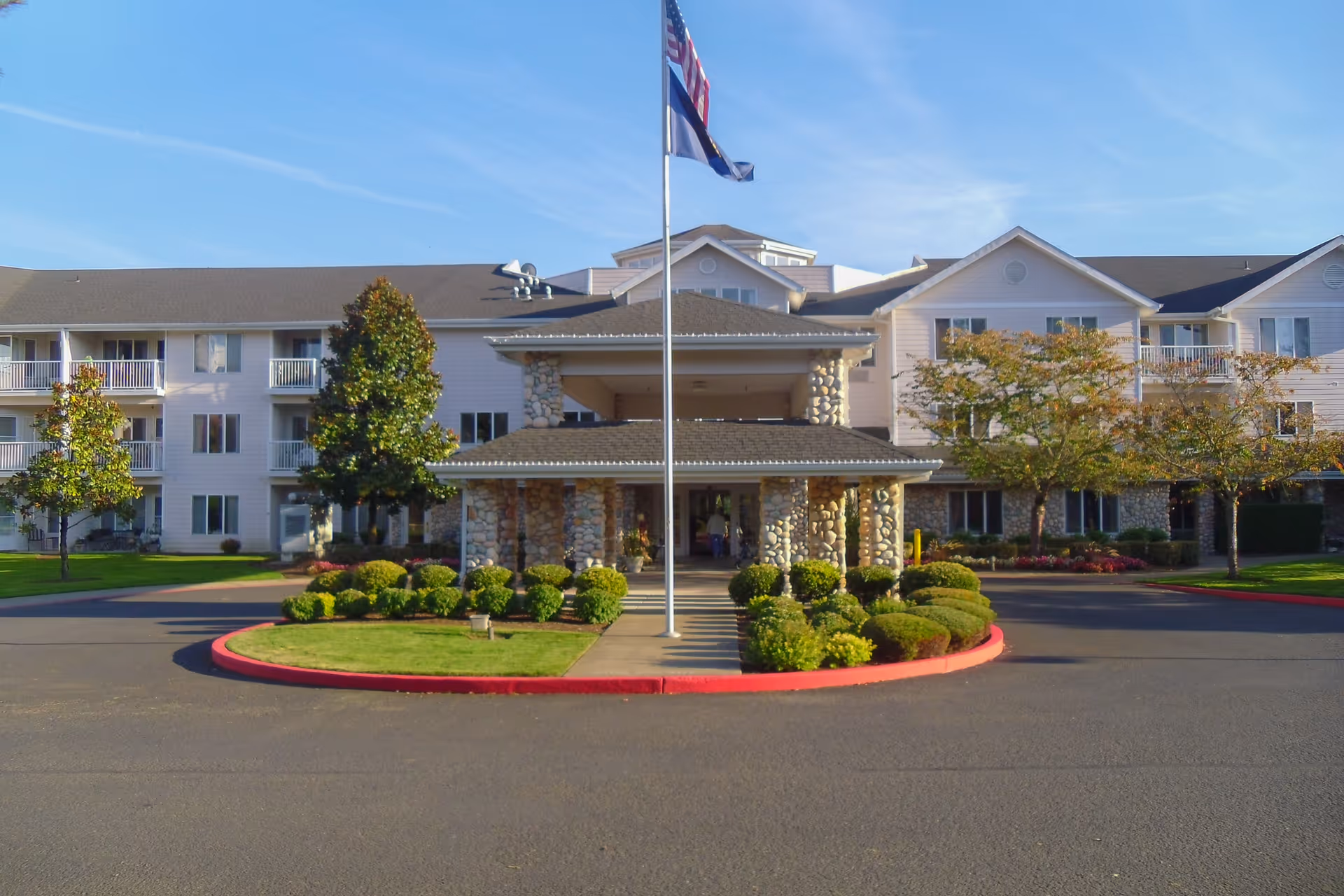 Exterior view of Somerset Lodge retirement living with circular driveway and flagpole.