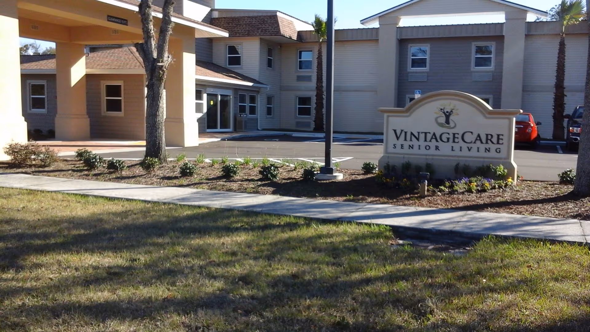 Exterior view of VintageCare Senior Living with a sign and landscaped entry.