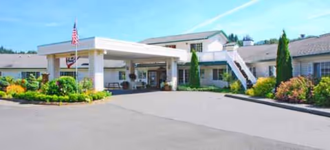 Exterior view of Brookdale Fairhaven senior living facility entrance with flag and landscaping.