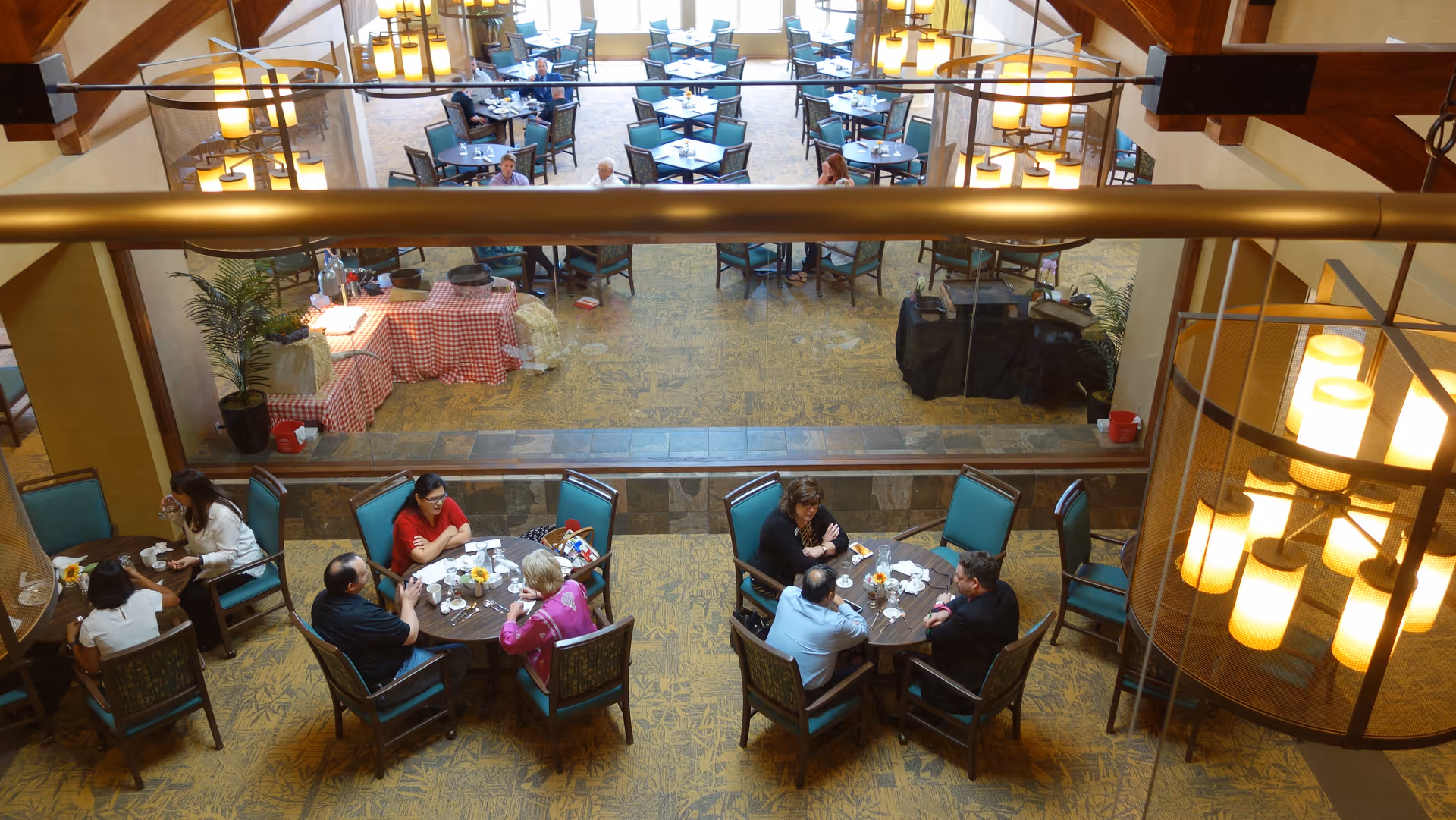 Overhead view of a retirement community dining room with multiple round tables and residents eating and socializing.