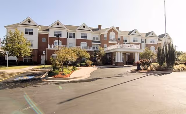 Exterior view of Quail Ridge Senior Living building with entrance and landscaped driveway.