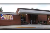 Front view of Pine Haven Nursing and Rehabilitation Center entrance with a flag banner.
