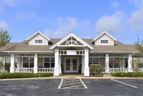 Front view of Taylor Place senior living facility with white columns and covered entrance.