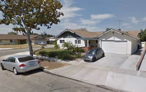 Front view of a single-story house with a driveway and two-car garage.