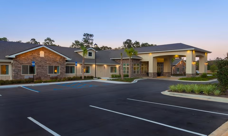 Exterior view of Boden Maplewood facility at dusk, showing a single-story building with stone and beige siding, a covered entrance, palm trees, and an empty parking lot with marked spaces including handicapped spots.