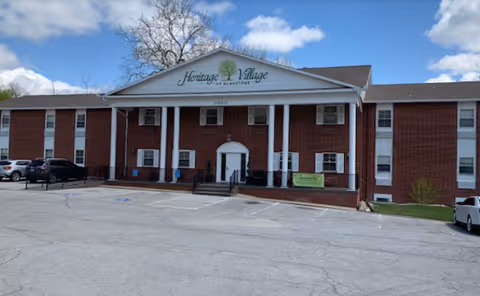 Front view of Heritage Village of Gladstone, brick building with a portico entrance.