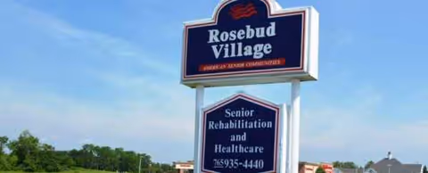 Outdoor sign reading 'Rosebud Village' in front of a senior care facility.