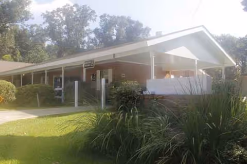 Exterior view of Tangi Pines Nursing Center with a covered entrance and landscaped front.