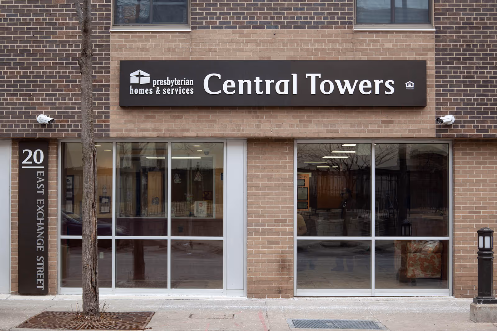 Brick exterior storefront with large windows and a sign reading "Central Towers" above the entrance.