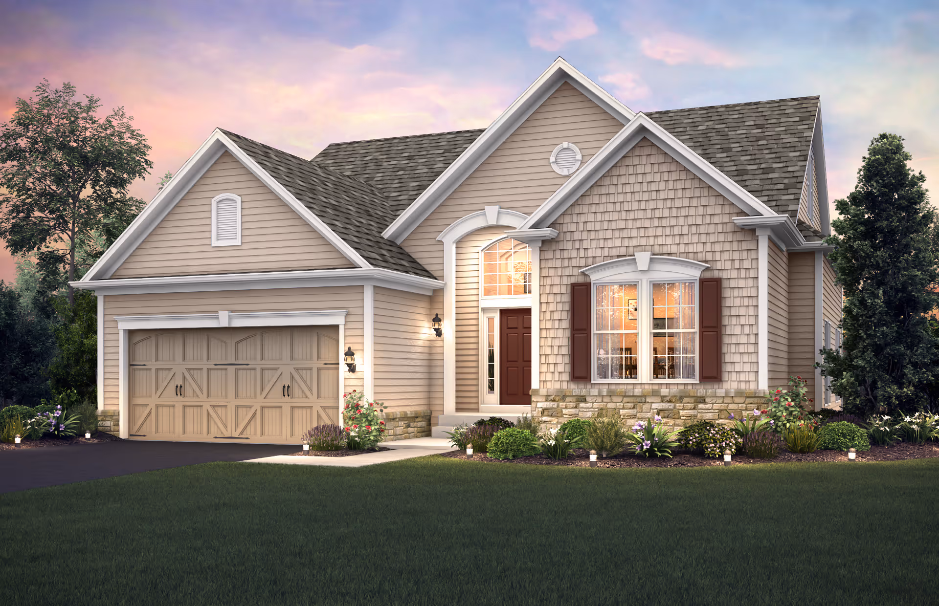 Exterior view of a single-story house with beige siding, a two-car garage, a front door with sidelights and a transom window, and a landscaped front yard with bushes and flowers under a colorful sunset sky.