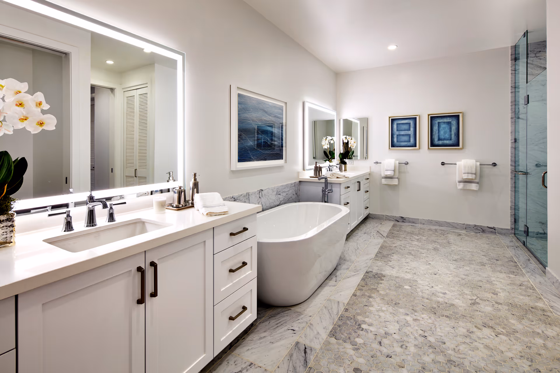 Bright modern bathroom with double vanity, freestanding bathtub, glass shower, and marble floors.