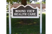 White-framed wooden sign on a lawn that reads 'Mound View Health Care'.