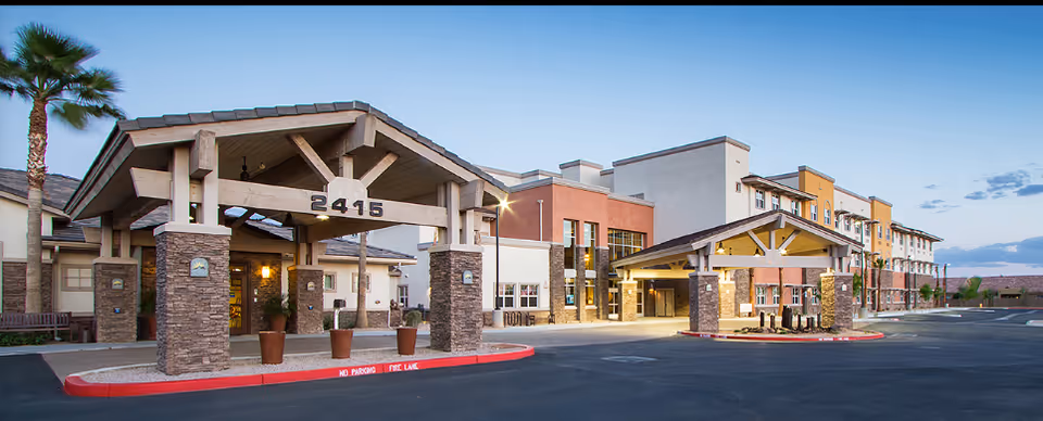 Exterior view of Summit at Sunland Springs senior living community with covered entrances and parking.