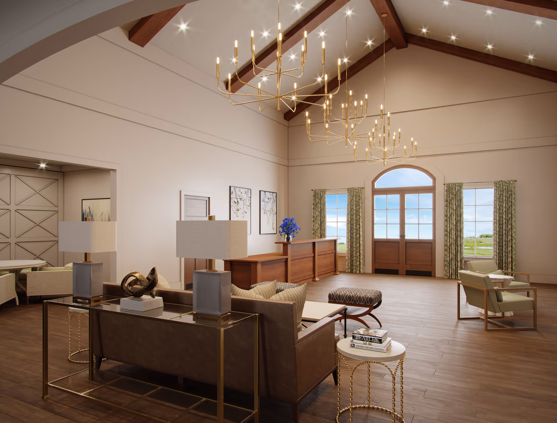 A spacious and elegant living room area with high vaulted ceilings featuring wooden beams and modern chandeliers. The room has large windows with green patterned curtains allowing natural light to fill the space. There is a wooden reception desk with a vase of blue flowers, a brown leather sofa with two table lamps behind it, a small round side table with books, and two armchairs with a small table between them. The flooring is wooden, and the overall decor is warm and inviting.