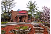 Exterior view of Northern Metropolitan senior living facility entrance with steps and landscaped path.