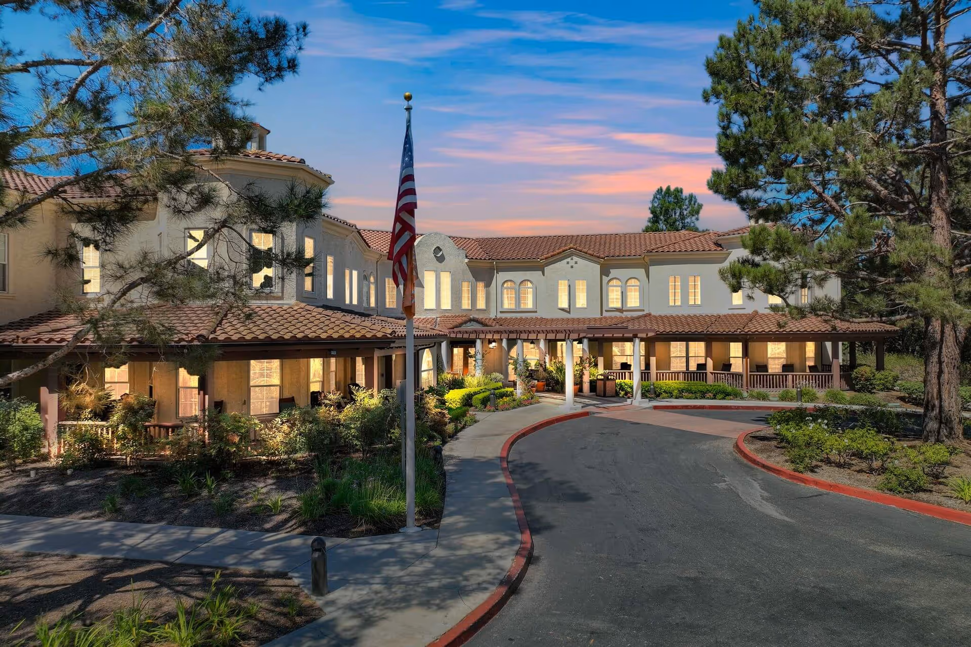 Sunrise of Mission Viejo exterior building with a circular driveway at dusk