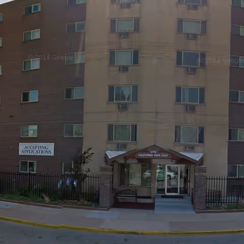 Exterior view of California Park East Apt, a multi-story senior living building with entrance canopy.