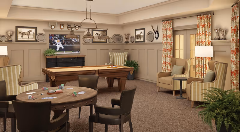 A cozy game room with a pool table in the center and a round poker table with playing cards and poker chips. The room has comfortable armchairs, a TV mounted on the wall showing a baseball game, decorative plates, trophies, and framed pictures on the walls. There are patterned curtains on the windows and plants adding greenery to the space.