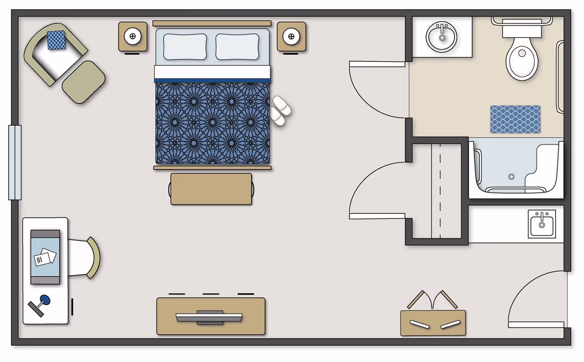 Floor plan of a senior living unit showing a bedroom with a bed, two nightstands, a chair with an ottoman, a desk with a chair, a TV stand, and a bathroom with a sink, toilet, and shower.