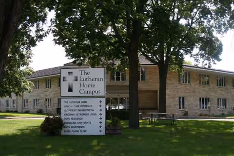 Exterior view of The Lutheran Home Campus building with sign and trees.