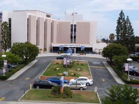 Exterior view of Alhambra Hospital Medical Center with entrance, parking, and manicured grounds.